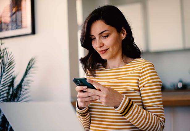 Persona mirando el teléfono móvil y sonriendo